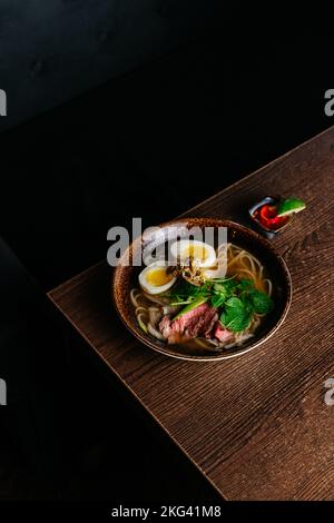 vietnamesische nationale Pho-Suppe auf einem Holztisch Stockfoto