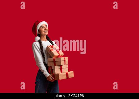 Wunderschöne Araberin In Santa Hat Mit Einem Stapel Geschenkboxen Stockfoto