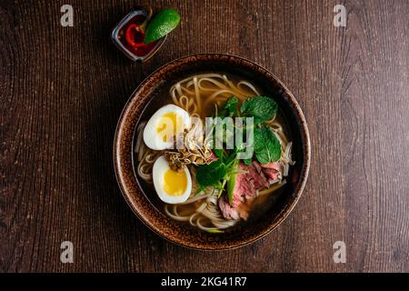 vietnamesische nationale Pho-Suppe auf einem Holztisch Stockfoto