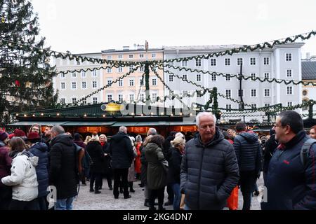 Salzburg, Österreich - 30. November 2019: Menschenmenge auf einem Weihnachtsmarkt in der Altstadt von Salzburg, Österreich, mit Weihnachtslichtern über dem Kopf aufgehängt Stockfoto