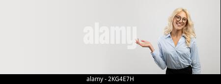 Geschäftswerbung. Wunderschöne Junge Geschäftsfrau Mit Brille, Die Auf Copy Space Zeigt Stockfoto