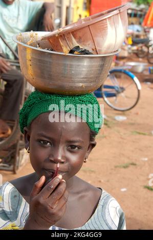 Mädchen mit Schüsseln auf dem Kopf, Natitingou, Atacora, Benin. In Afrika lernen Mädchen, alles auf dem Kopf zu tragen - sehr gut für die Haltung. Stockfoto