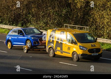 AA-Rettungsfahrzeug oder -Van, der ein abgebrochenes Auto auf einem Anhänger entlang der Autobahn M3, England, Großbritannien, schleppt. Automobilverband, Pannenorganisation Stockfoto