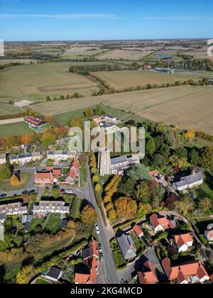 Eine vertikale Luftaufnahme des Dorfes Monks Eleigh in Suffolk, umgeben von üppiger Natur im Sonnenlicht Stockfoto