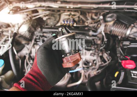 Nahaufnahme der EGR-Abgasrückführung in der Auto-mechanischen Hand, Fahrzeugteilekonzept. Stockfoto