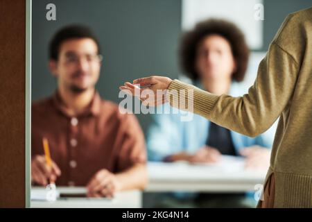 Selektiver Fokus auf die Hand eines reifen Lehrers oder Sprechers, der während des Seminars neue Themen vor den Schülern präsentiert Stockfoto