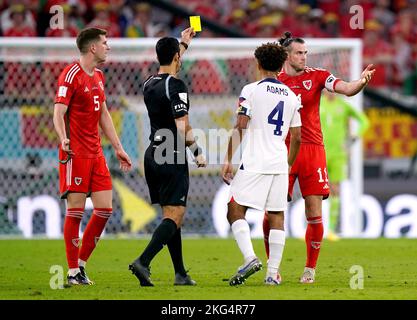 Der walisische Gareth Bale (rechts) reagiert, nachdem er während des Spiels der FIFA-Weltmeisterschaft der Gruppe B im Ahmad bin Ali Stadium in Al-Rayyan eine gelbe Karte von Schiedsrichter Abdulrahman Al-Jassim erhalten hat. Bilddatum: Montag, 21. November 2022. Stockfoto