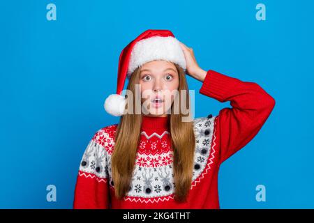 Foto einer verblüfften, verängstigten Frau, Kopfbedeckungen, die negative Nachrichten beeindrucken, offener Mund, isoliert auf blauem Hintergrund Stockfoto