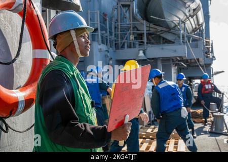 221029-N-TC847-1061 ADRIA (OKT 27, 2022) Fire Boatswain’s Mate Seaman Rayshaun Black, der dem Ticonderoga-Klasse Lenkraketen-Kreuzer USS Leyte Gulf (CG 55) zugewiesen wurde, signalisiert dem Flottennachfüllungsöler USNS William McLean (T-AKE 12) während eines Auffüllens auf See, 29. Oktober 2022. The George H.W. Die Bush Carrier Strike Group befindet sich im geplanten Einsatzgebiet der US Naval Forces Europe, das von der Sechsten Flotte der USA eingesetzt wird, um die Interessen der USA, der Alliierten und der Partner zu verteidigen. Stockfoto