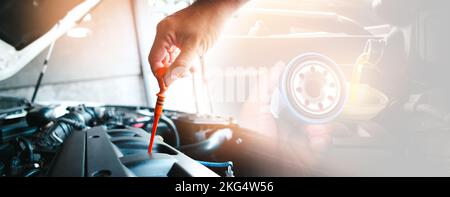 Der Mechaniker zieht den Schmierstab und den Ölfilter in die Hand mit Öl, das zum Motor fließt, doppelte Belichtung auf dem Hintergrund, Auto-Wartung servi Stockfoto