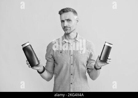 Guy wählen Shampoo-Flasche oder Haarspülung. Tägliche Gewohnheiten und persönliche Pflege. Stockfoto