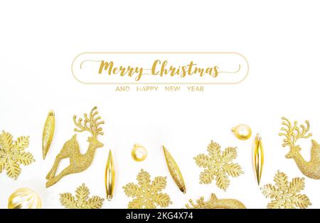 frohe weihnachten und ein frohes Neujahrsfest, goldene Dekoration mit Schneeflockenbällen und nachgestellten Rentieren auf weißem Hintergrund Stockfoto