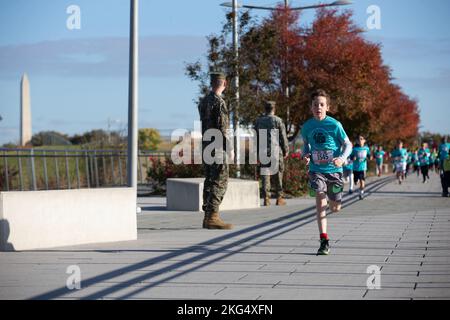 Kinder Rennen bis zum Ziel während des Marine Corps Marathon Kids Run in Arlington, Virginia, 29. Oktober 2022. Der One Mile Fun Run bot Kindern im Alter von 5-12 Jahren die Möglichkeit, mit Marines zu laufen; er beendete das Camp Miles, wo Familien Aktivitäten, Unterhaltung und Spiele genießen konnten. Stockfoto