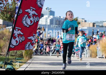 Kinder Rennen bis zum Ziel während des Marine Corps Marathon Kids Run in Arlington, Virginia, 29. Oktober 2022. Der One Mile Fun Run bot Kindern im Alter von 5-12 Jahren die Möglichkeit, mit Marines zu laufen; er beendete das Camp Miles, wo Familien Aktivitäten, Unterhaltung und Spiele genießen konnten. Stockfoto