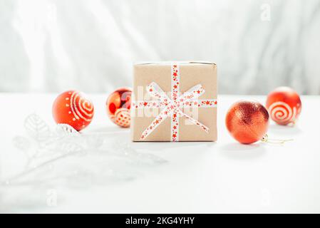 Geschenkbox mit rotem Band und roter weihnachtsdekor Stockfoto