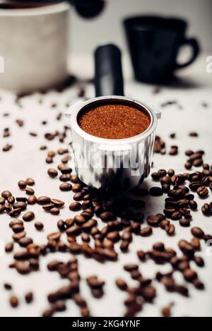 Portafilter mit gemahlenem Kaffee auf hellgrauem Hintergrund. Der Blick von oben. Stockfoto