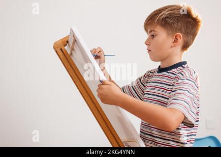 Ein Junge malt zu Hause ein Bild. Hobbys von Kindern im Alter von 8 Jahren Stockfoto