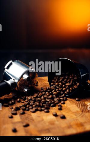 Kaffeebohnen in der Nähe der Tasse und Portafilter zum Zubereiten von Kaffee auf einer Kaffeemaschine. Stockfoto