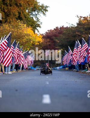 Handradler fahren während des Marine Corps Marathon 47. in Hains Point, Washington D.C., 30. Oktober, durch die „Wear Blue: Run to Remember“-Meile. 2022. Die Meile „Wear blue: Run to Remember“ ist eine Hommage an die Menschen, die ihr Leben für dieses Land hingegeben haben, und zeigt 225 Poster mit Fotos der Gesichter der Gefallenen. Stockfoto