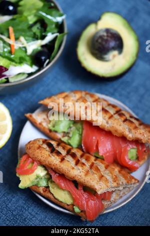 Lachs-Sandwich mit Avocado und Salat. Stockfoto