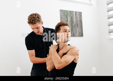 Männlicher Therapeut-Massagesportler - das Konzept des Physiotherapeutischen Sports Stockfoto