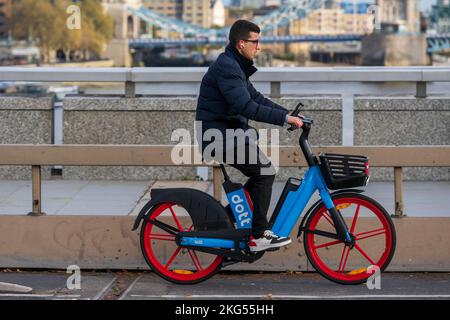 Ein Mann pendelt während der Hauptverkehrszeit mit einem Dott-Elektrofahrrad entlang der London Bridge. London Bridge, London, Großbritannien. 17. November 2022 Stockfoto