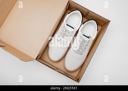 Neue weiße Schuhe im Karton. Sportliche Männerschuhe auf weißem Hintergrund Stockfoto