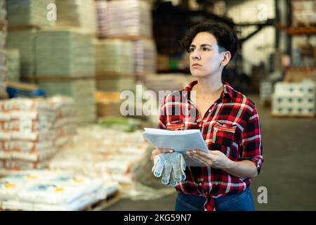 Frau überprüft die Unterlagen im Lager Stockfoto