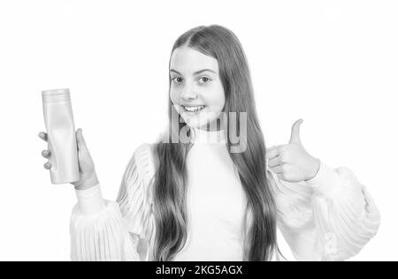 Glückliches Kind präsentiert Produkt von Shampoo Haarspülung oder Duschgel zeigen Daumen nach oben, Lotion. Stockfoto