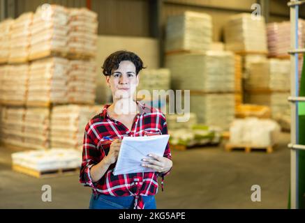 Die weibliche Lagerhalterin überprüft das Vorhandensein von Waren im Baustofflager Stockfoto