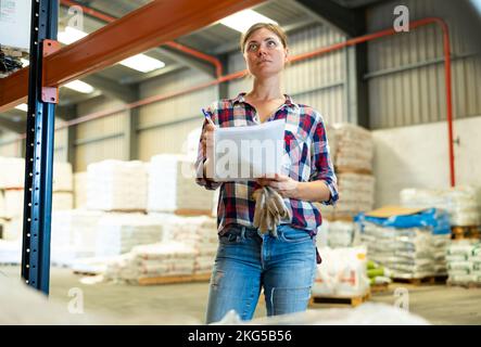 Frau überprüft die Unterlagen im Lager Stockfoto