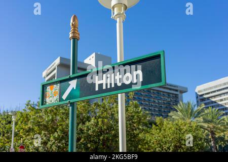 Anaheim, CA, USA – 1. November 2022: Ein Straßenschild in Richtung Hilton Hotel im Convention Center District in Anaheim, Kalifornien. Stockfoto