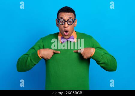 Nahaufnahme Foto eines jungen, witzigen, befragten Mannes trägt grüne Pullover-Finger direkt, ohne zu wissen, wer isoliert auf blauem Hintergrund verantwortlich ist Stockfoto