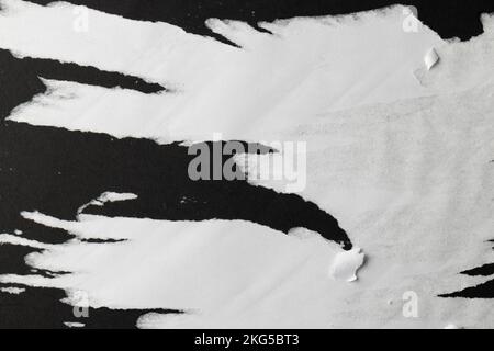 Zerrissene Stücke weißes Papier auf schwarzem Hintergrund Stockfoto