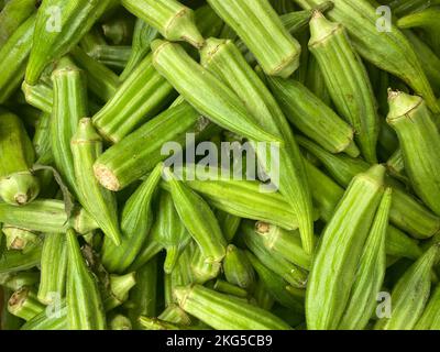 Frischer grüner Okra, gesundes Essen, Nahaufnahme von Okra, Hintergrund, frische Okras vom lokalen Bauernmarkt, Bio-Produkte im Supermarkt Stockfoto