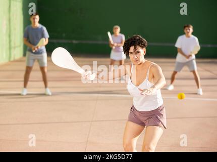 Frau baskische Pelota Spieler schlagen Ball mit Holzschläger Stockfoto