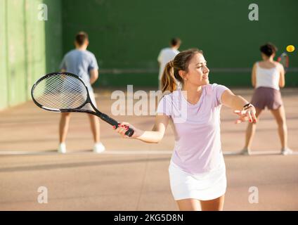 Frau Pelota Spieler schlagen Ball mit Schläger Stockfoto