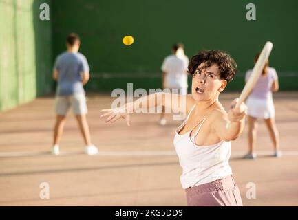 Junge Argentinierin, die im Sommer Pelota an der Freiluftfront spielt Stockfoto