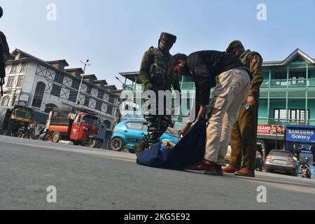 21. November 2022, Srinagar, Jammu und Kashmir, Indien: Ein indischer paramilitärischer Trooper frisselt am 21. November 2022 bei einer zufälligen Durchsuchungen entlang einer Straße in Srinagar die Habseligkeiten eines Mannes. (Bild: © Mubashir Hassan/Pacific Press via ZUMA Press Wire) Stockfoto