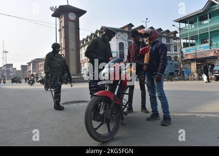 21. November 2022, Srinagar, Jammu und Kashmir, Indien: Ein indischer paramilitärischer Trooper frisselt am 21. November 2022 bei einer zufälligen Durchsuchungen entlang einer Straße in Srinagar die Habseligkeiten eines Mannes. (Bild: © Mubashir Hassan/Pacific Press via ZUMA Press Wire) Stockfoto