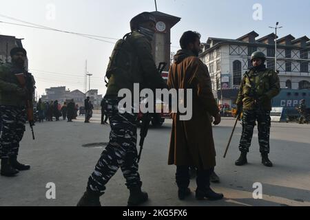 21. November 2022, Srinagar, Jammu und Kashmir, Indien: Ein indischer paramilitärischer Trooper frisselt am 21. November 2022 bei einer zufälligen Durchsuchungen entlang einer Straße in Srinagar die Habseligkeiten eines Mannes. (Bild: © Mubashir Hassan/Pacific Press via ZUMA Press Wire) Stockfoto