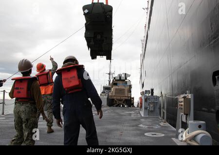 221005-N-DK042-1217 HAFEN VON KUSHIRO, Japan (5. Oktober 2022) Matrosen des Amphibienbaubataillons (ACB) 1 und des Frachthandhabungsbataillons der Marine (NCHB) 1, als Teil des Navy Support Elements zur Unterstützung der Operation Resolute Dragon 22, Senken Sie einen Lastenauflieger mit Leitungen während des Kranbetriebs auf das Deck eines verbesserten Schiffs der Marine ab, während er bei USNS Dahl (T-AKR 312) in Kushiro Port, Japan, am 5. Oktober 2022 festgemacht wurde. USS Benfold (DDG 65), USNS Dahl (T-AKR 312) und USNS Sacagawea (T-AKE 2) beteiligen sich an der gemeinsamen bilateralen Integration mit der III Marine Expeditionary Force (III M Stockfoto