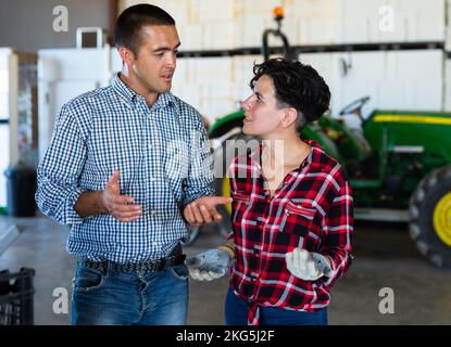 Bauern und Bauern sprechen neben dem Traktor Stockfoto