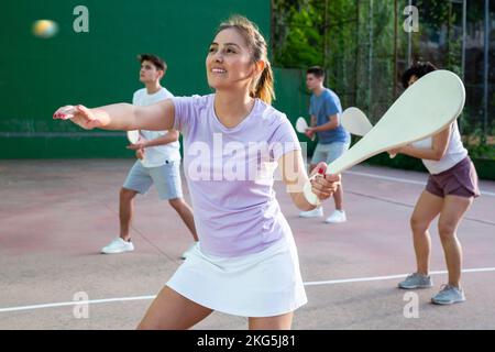 Junge Argentinierin, die im Sommer Pelota an der Freiluftfront spielt Stockfoto