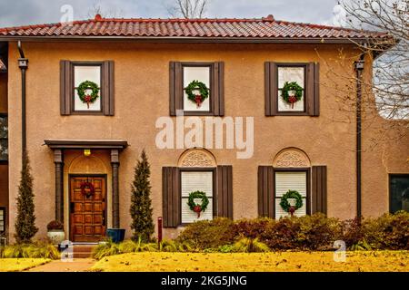 Stuck zweistöckiges Haus mit Fliesendach dekoriert für Weihnachten mit Kränzen in allen Fenstern Stockfoto