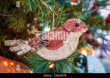 Rustikale Weihnachtsdekoration mit Vogel aus Blättern, Zweigen und Leinenholz - vom Baum hängend - Nahaufnahme und selektiver Fokus Stockfoto