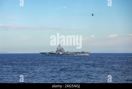 MITTELMEER (Nov 16, 2022) Ein französischer Rafale-Kampfjet fliegt während des Flugbetriebs am 16. November 2022 über den französischen Flugzeugträger FS Charles de Gaulle (R 91). Der Arleigh Burke-Klasse Lenkraketen-Zerstörer USS Roosevelt befindet sich im geplanten Einsatzgebiet der US Naval Forces Europe, das von der US Sixth Fleet eingesetzt wird, um die Interessen der USA, der Alliierten und der Partner zu verteidigen. (USA Navy Foto von Mass Communication Specialist 2. Class Danielle Baker/veröffentlicht) Stockfoto