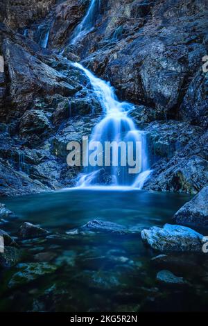 Schöner Wasserfall mit verschwommenem Wassereffekt. Foto im Tal der fünf Teiche in der polnischen Tatra. Foto mit langer Belichtung. Stockfoto