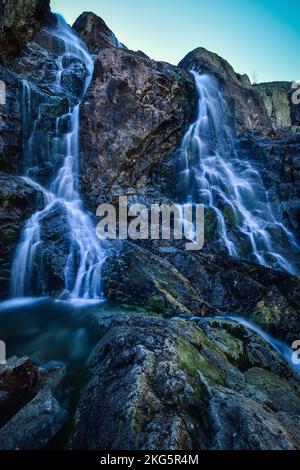 Schöner Wasserfall mit verschwommenem Wassereffekt. Foto im Tal der fünf Teiche in der polnischen Tatra. Foto mit langer Belichtung. Stockfoto