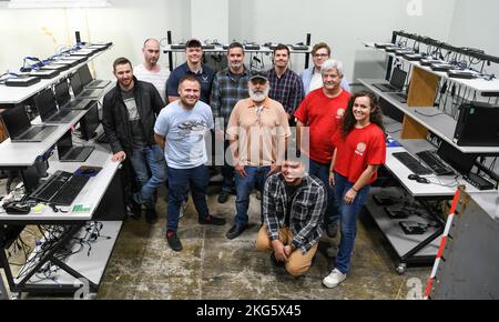 Techniker von Computernetzwerken posieren für ein Foto im Computer-Staging-Bereich der Arnold Air Force Base, Tennessee, 5. Oktober 2022. Sie haben daran gearbeitet, eine Flut von Computerersatzanlagen für die Teammitglieder des Arnold Engineering Development Complex zu installieren. Stockfoto